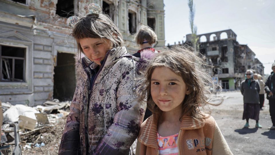 Rússia anuncia plano de reconstrução de regiões ucranianas Crianças andam nas ruas do centro de Mariupol, na Ucrânia, em maio de 2022.