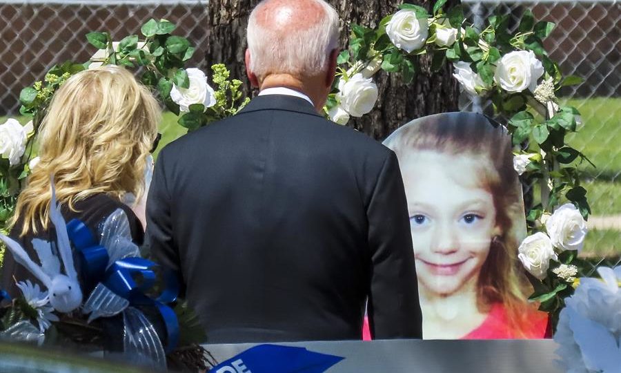 Jill Biden e Joe Biden, de costas, observam foto de menina cercada por coroas de flores na frente da escola em que ela, dezoito outras crianças e duas professoras foram mortas por um atirador no dia 24.