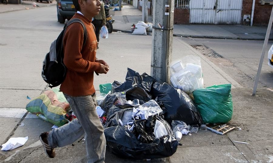 Cidadão caminha entre o lixo que se acumulou nas ruas de Bogotá, em 20 de dezembro de 2012