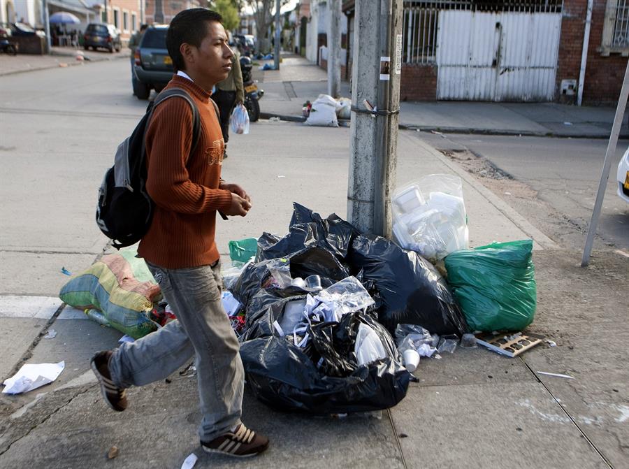 Cidadão caminha entre o lixo que se acumulou nas ruas de Bogotá, em 20 de dezembro de 2012