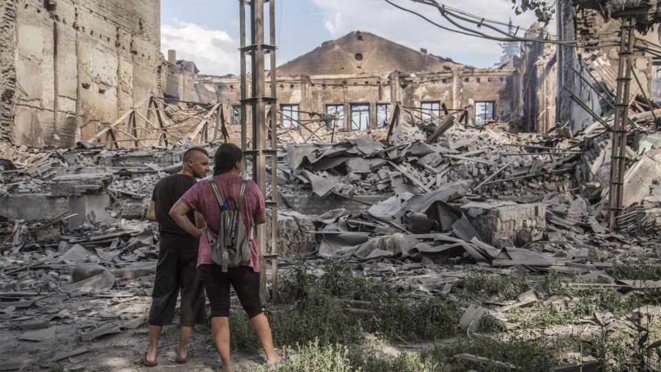 Moradores observam edifícios destruídos em Lysychansk após intensos combates na área de Luhansk, em 18 de junho