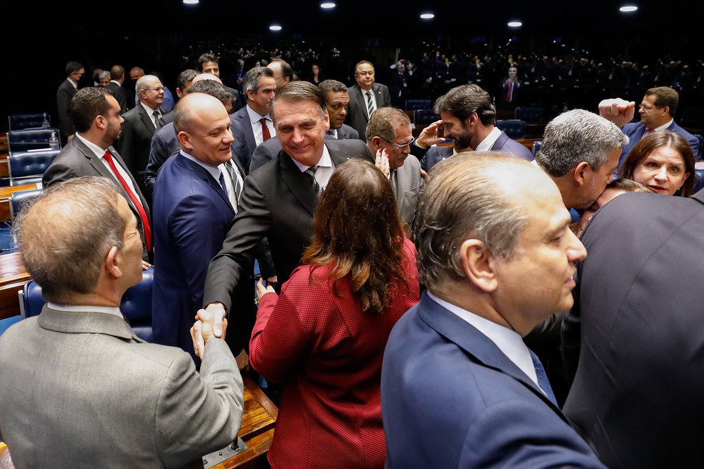 Bolsonaro é cercado por deputados em sessão especial do Congresso: tentativa de formar base do governo com bancadas parlamentares fracassou já no primeiro ano de governo.