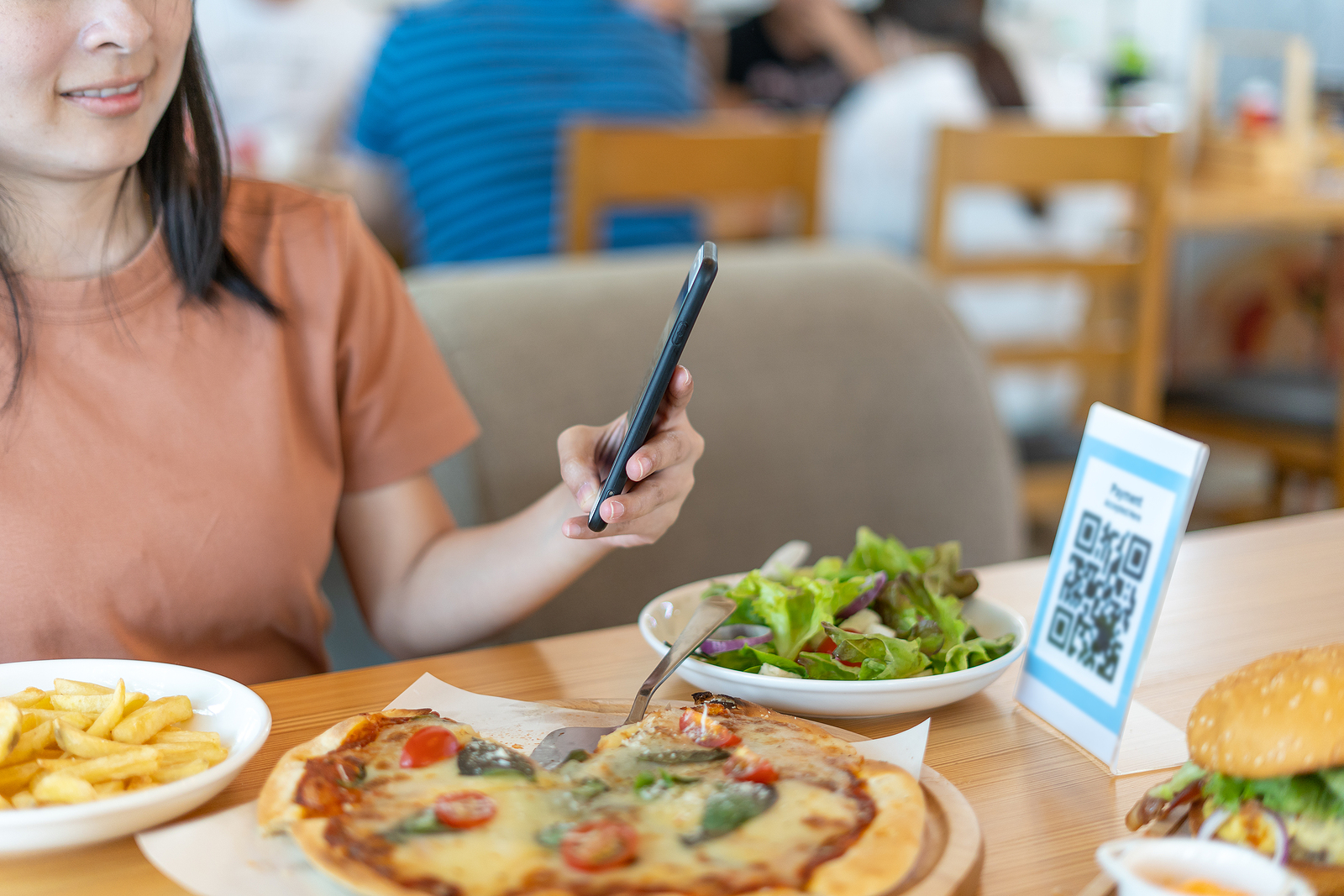 Mulher acessa cardápio com QR Code