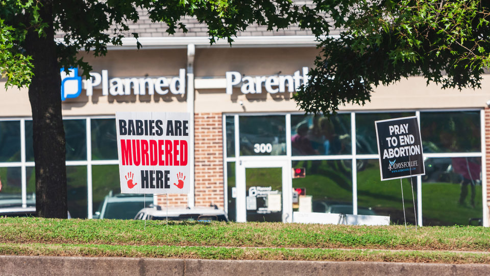 Clínica na Planned Parenthood, nos Estados Unidos, com cartazes pró-vida colados na fachada
