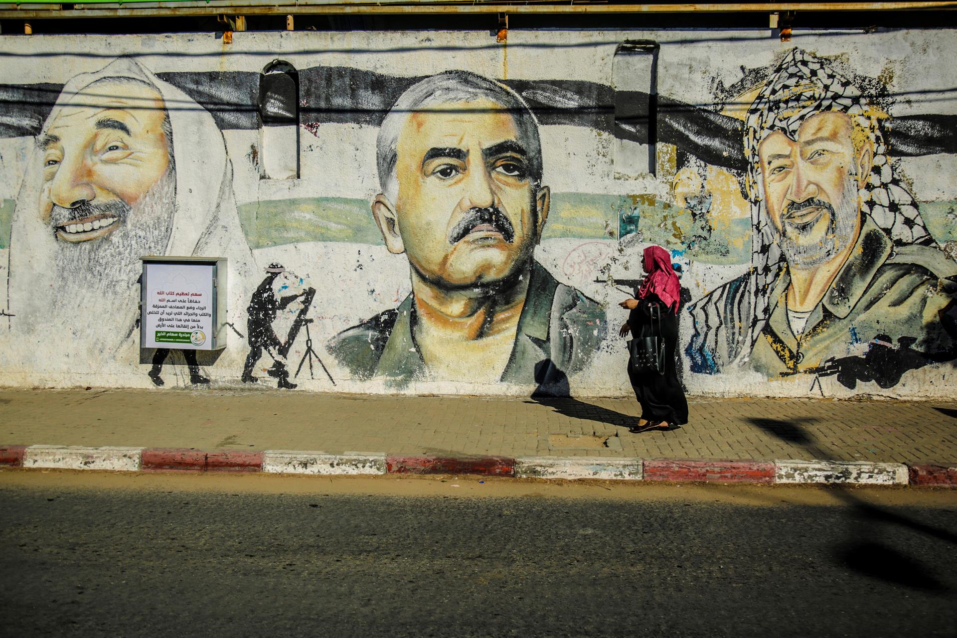 Vista de um mural em uma rua de Gaza, com imagens de líderes palestinos.