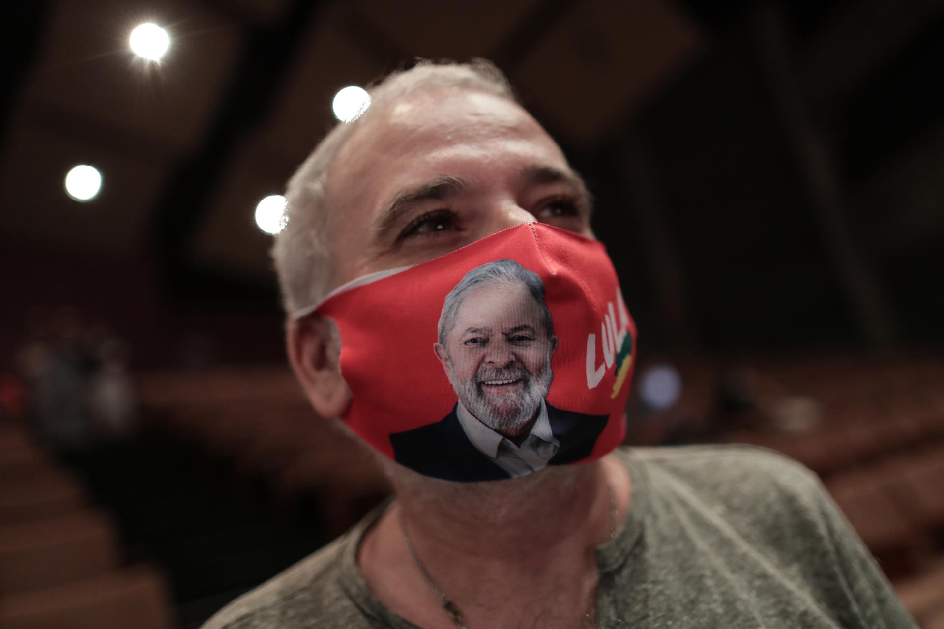Homem usa máscara ilustrada para a campanha presidencial de Lula em março de 2022 em evento na UERJ, Rio de Janeiro. As melhores revisões científicas não apoiaram a eficácia das máscaras, mas muitos progressistas continuam insistindo que são uma boa ideia.