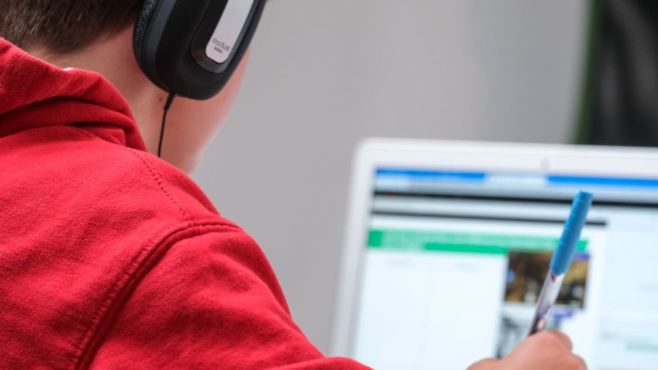Menino usando computador para estudar