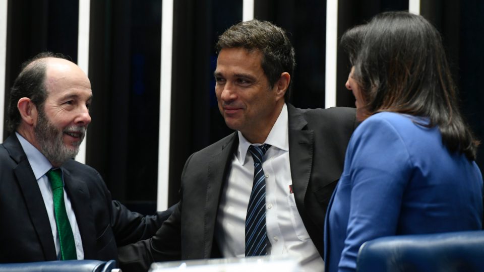 O presidente do Banco Central, Roberto Campos Neto (ao centro), ao lado de Arminio Fraga, ex-presidente do BC, e da ministra Simone Tebet, em evento no Senado na semana passada: Copom tende a ignorar pressão do governo e manter juros.