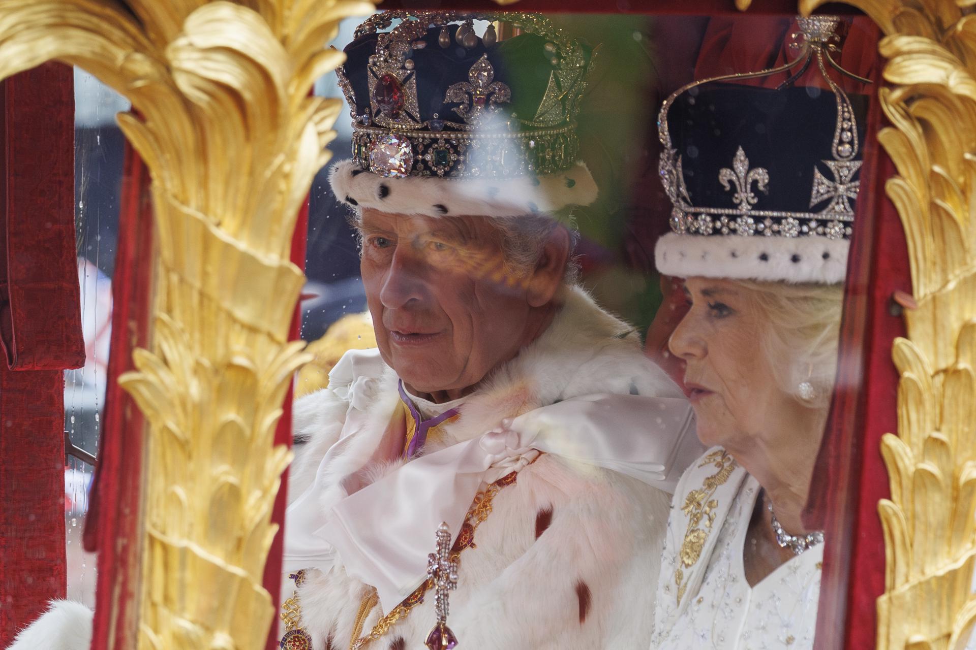 Rei Charles III com a rainha Camilla, após a coroação, em uma carruagem de ouro em procissão ao palácio de Buckingham. Ativistas antimonarquia dizem que foram detidos arbitrariamente, polícia de Londres rebate que manifestação estática foi permitida.