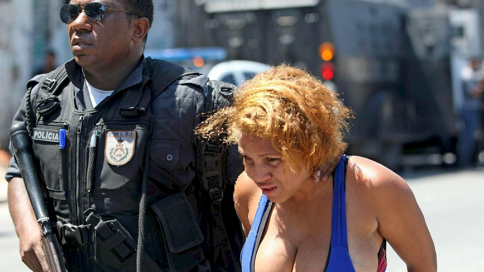 Policial militar prende suspeita de traficar drogas durante operação contra gangues na favela da Grota, no Rio de Janeiro, em 28 de novembro de 2010.