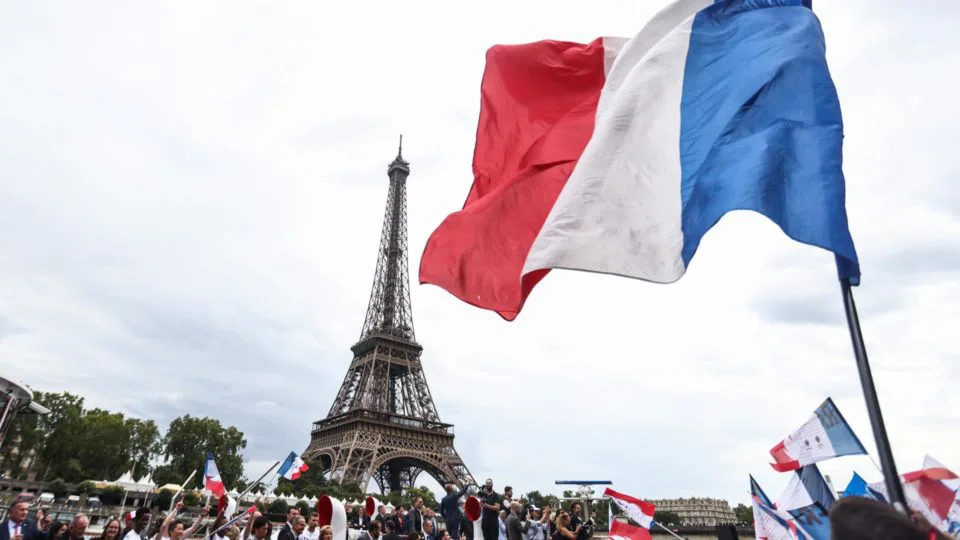 Desfile com a Tocha Olímpica às margens do rio Sena, perto da Torre Eiffel, em Paris