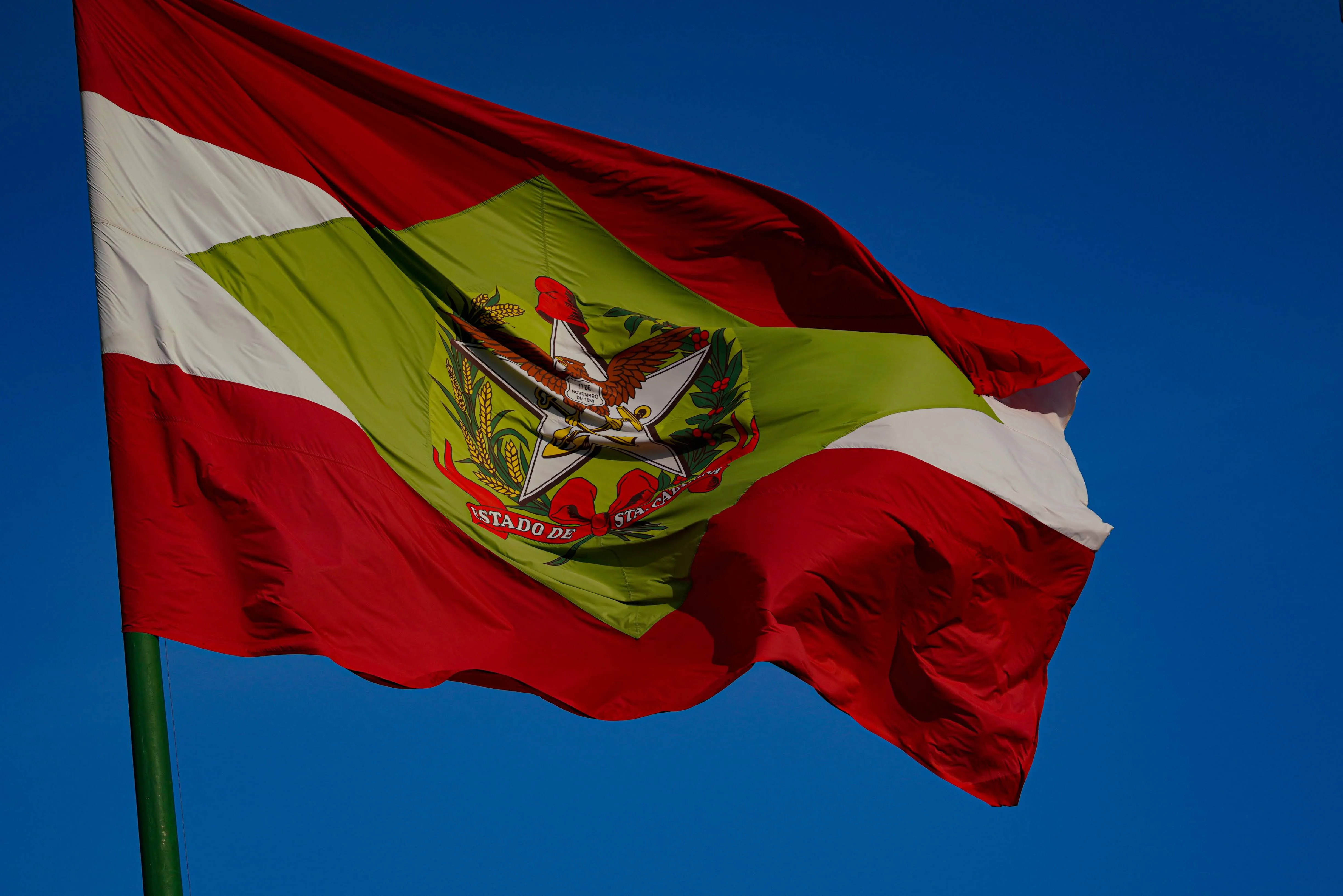 Substituição completa da letra do hino de Santa Catarina é justificada pela falta de adequação com o estado, mas enfrenta acusações de apagamento cultural.