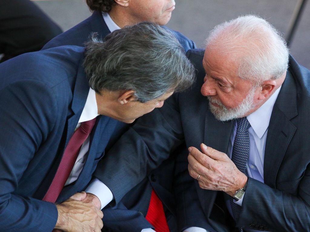 Ministro da Fazenda, Fernando Haddad, cumprimenta o presidente da República, Luiz Inácio Lula da Silva: queda de arrecadação fiscal, desaceleração do PIB e guerra no Oriente Médio pioram expectativas para a economia em 2024.