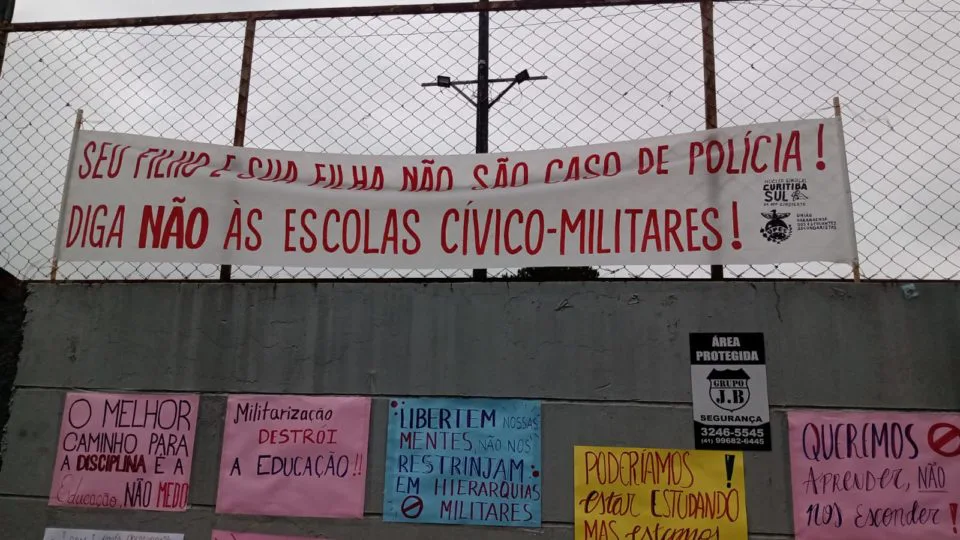 Cartazes com frases contrárias ao modelo cívico-militar têm ocupado espaços em escolas da rede estadual do Paraná.