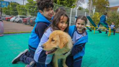 Menino feliz abraçando seu cachorro no jardim