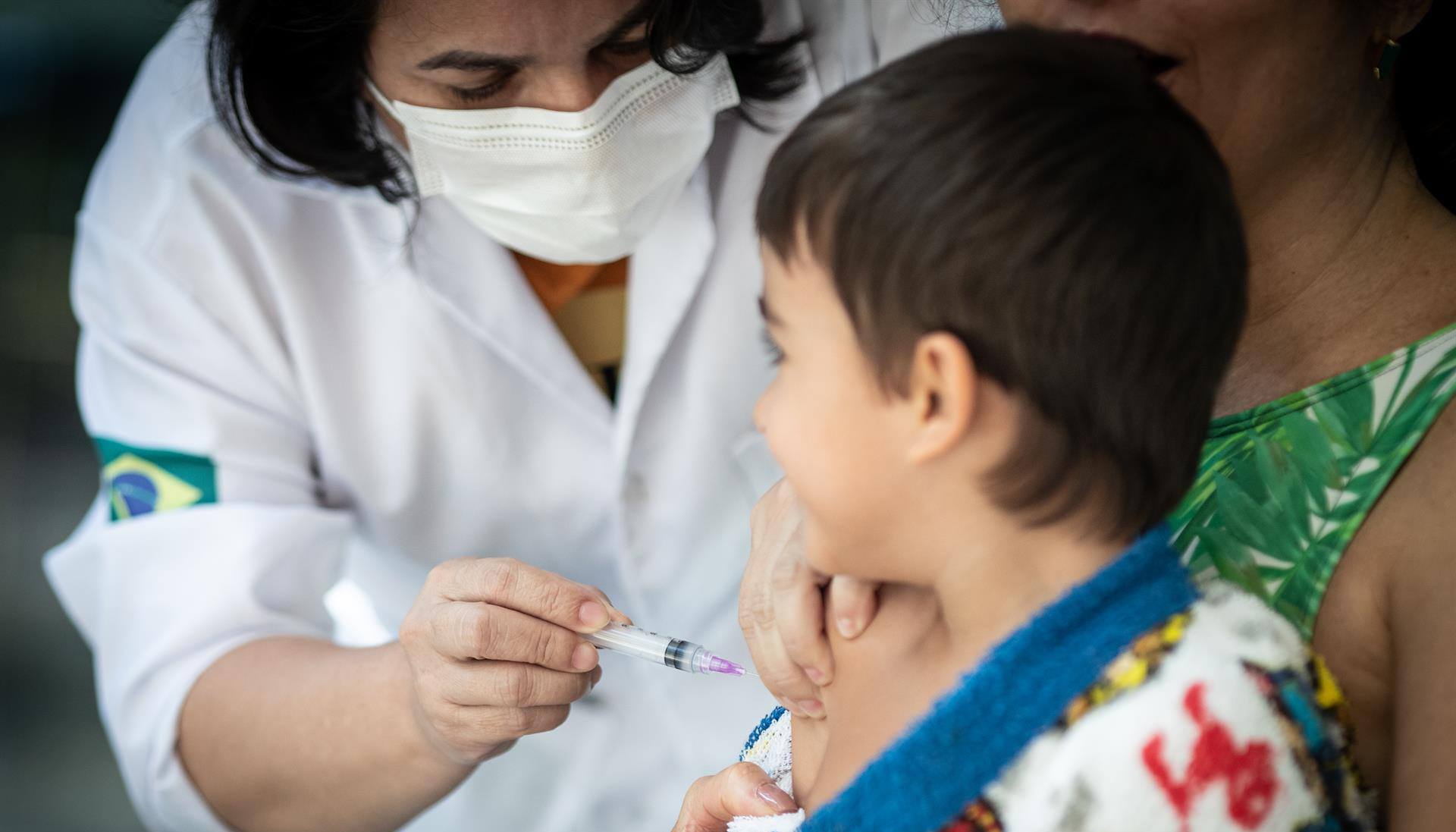 Criança é vacinada contra Covid-19 no Rio de Janeiro em 2022. O Conselho Federal de Medicina quer ouvir os médicos a respeito da inclusão das vacinas da Covid entre as obrigatórias do Programa Nacional de Imunizações.