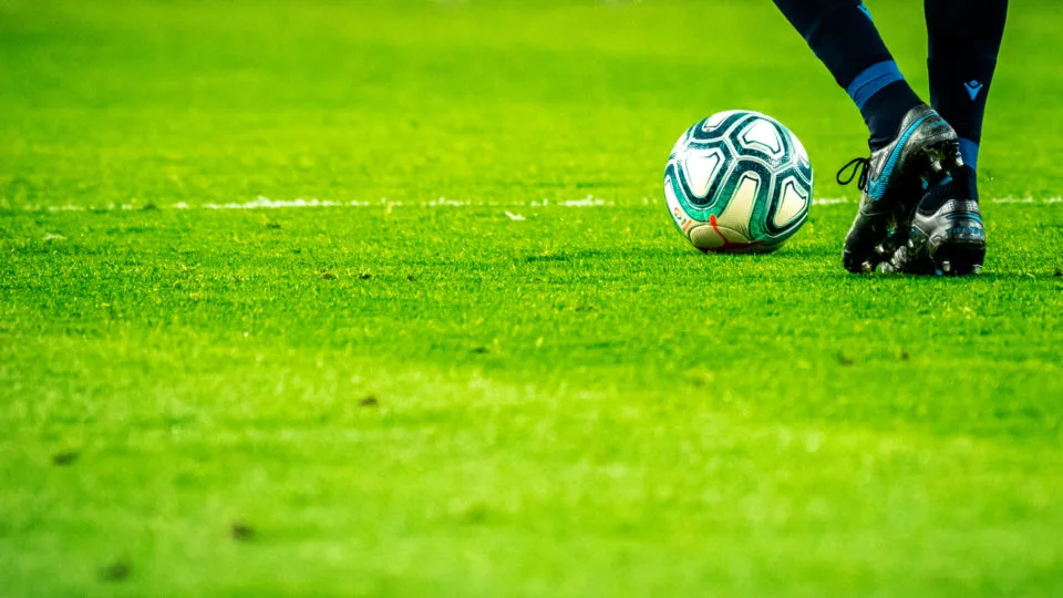Homem que joga o jogo de futebol no campo