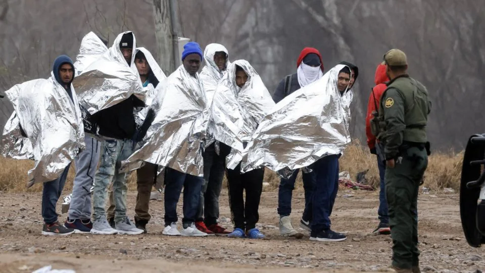 Biden x Texas: Migrantes fazem fila enquanto se preparam para serem recolhidos pelos agentes da Patrulha de Fronteira em Eagle Pass, Texas, EUA, 14 de janeiro de 2024.