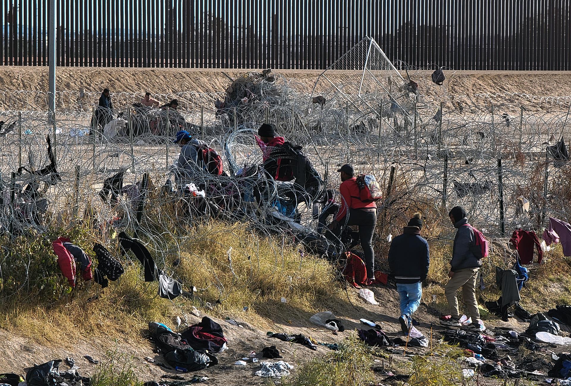 Migrantes atravessam o Rio Grande, próximo ao muro que separa a fronteira dos EUA, em Ciudad Juárez, Chihuahua, México, no dia em 29 de dezembro de 2023. Os migrantes lotam as ruas de Ciudad Juárez, na fronteira norte do México.