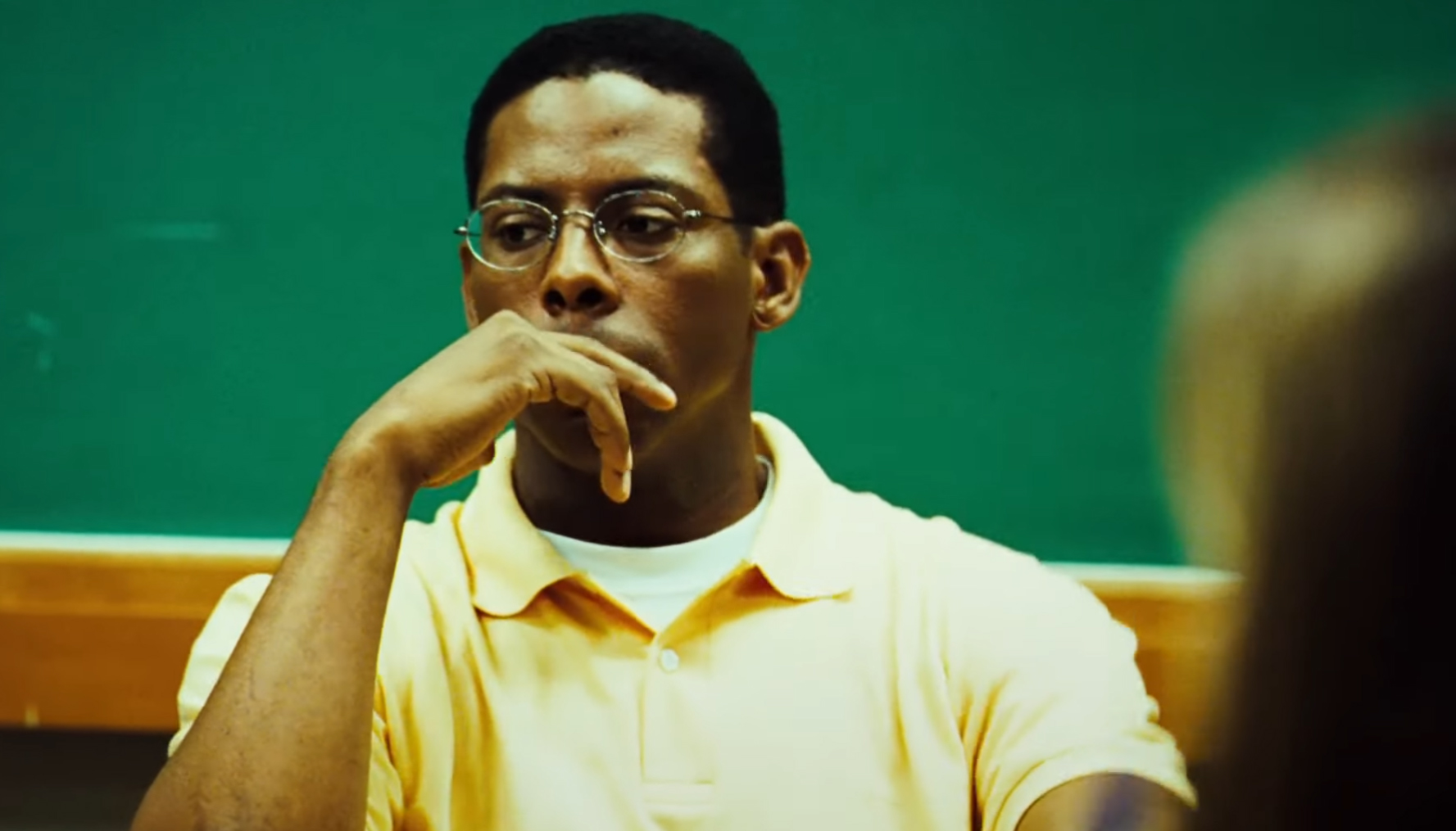 Personagem André Matias em semblante frustrado ao debater com colegas de universidade sobre Foucault e criminalidade, no filme Tropa de Elite (2007).