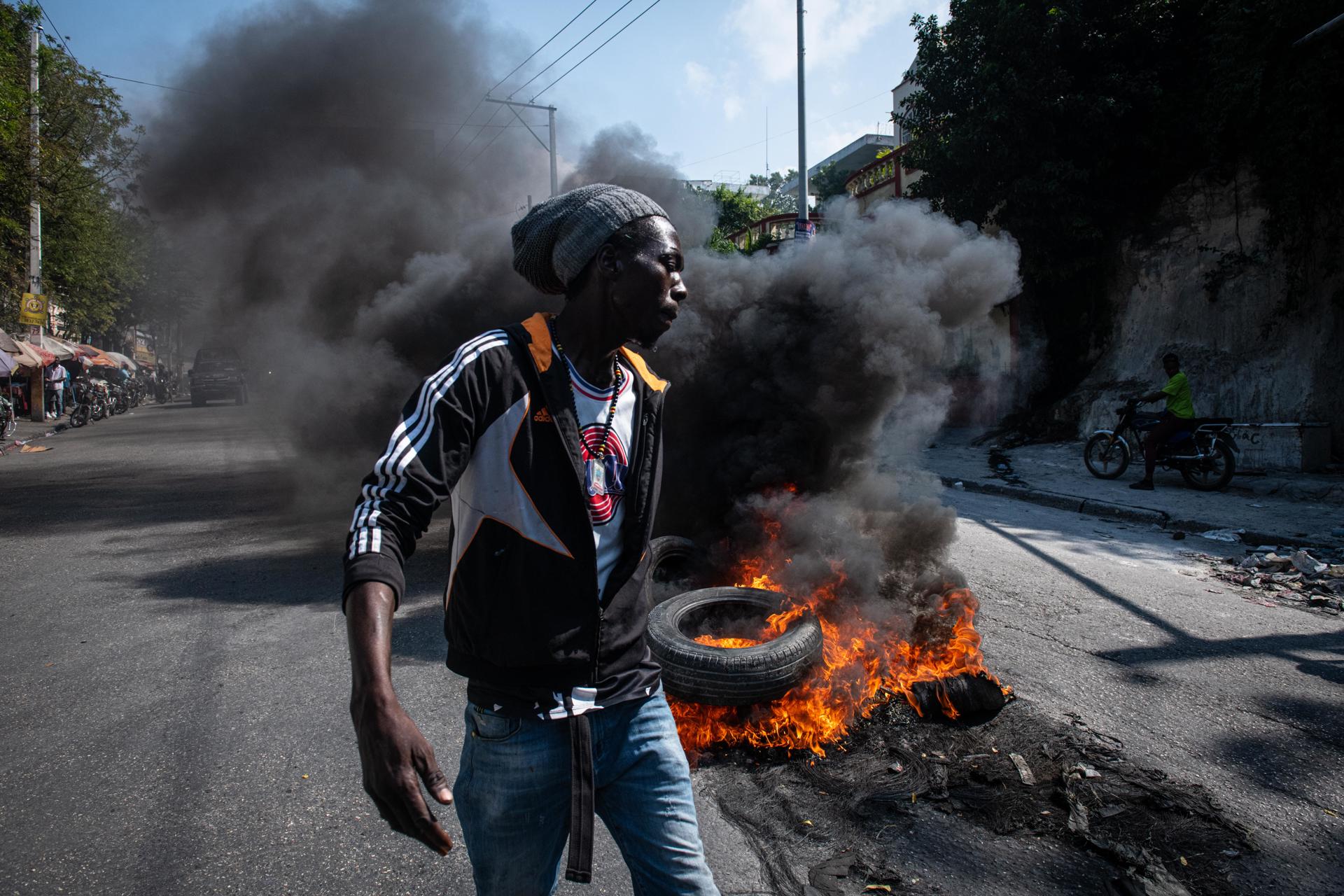 Manifestantes ateiam fogo a pneus durante protesto nesta terça-feira (12) em Porto Príncipe (Haiti).