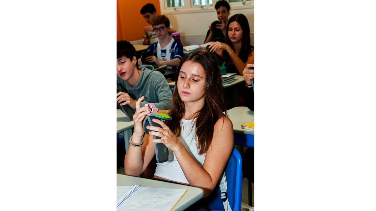 Escola percebe melhora na socialização após adoção de estojo que tranca celulares durante as aulas.