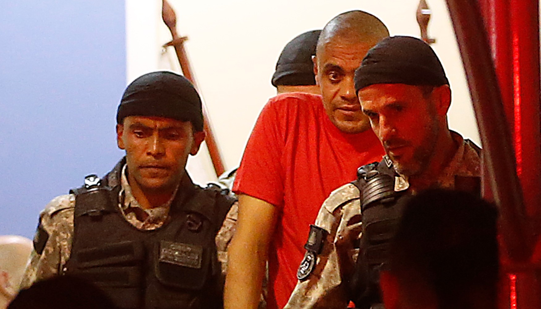 Adélio Bispo (de vermelho), autor da tentativa de assassinato contra Jair Bolsonaro, é levado pela Polícia Federal em Juiz de Fora após o interrogatório em 7 de setembro de 2018. Bispo foi absolvido por insanidade, mas está em um presídio.