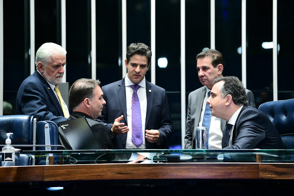 Na imagem (em sentido horário): Flávio Bolsonaro, Jaques Wagner, secretário-geral da Mesa do Senado, Gustavo Vieira, Vanderlan Cardoso e Rodrigo Pacheco durante sessão sobre projeto que pretende sustar decreto de armas de Lula.