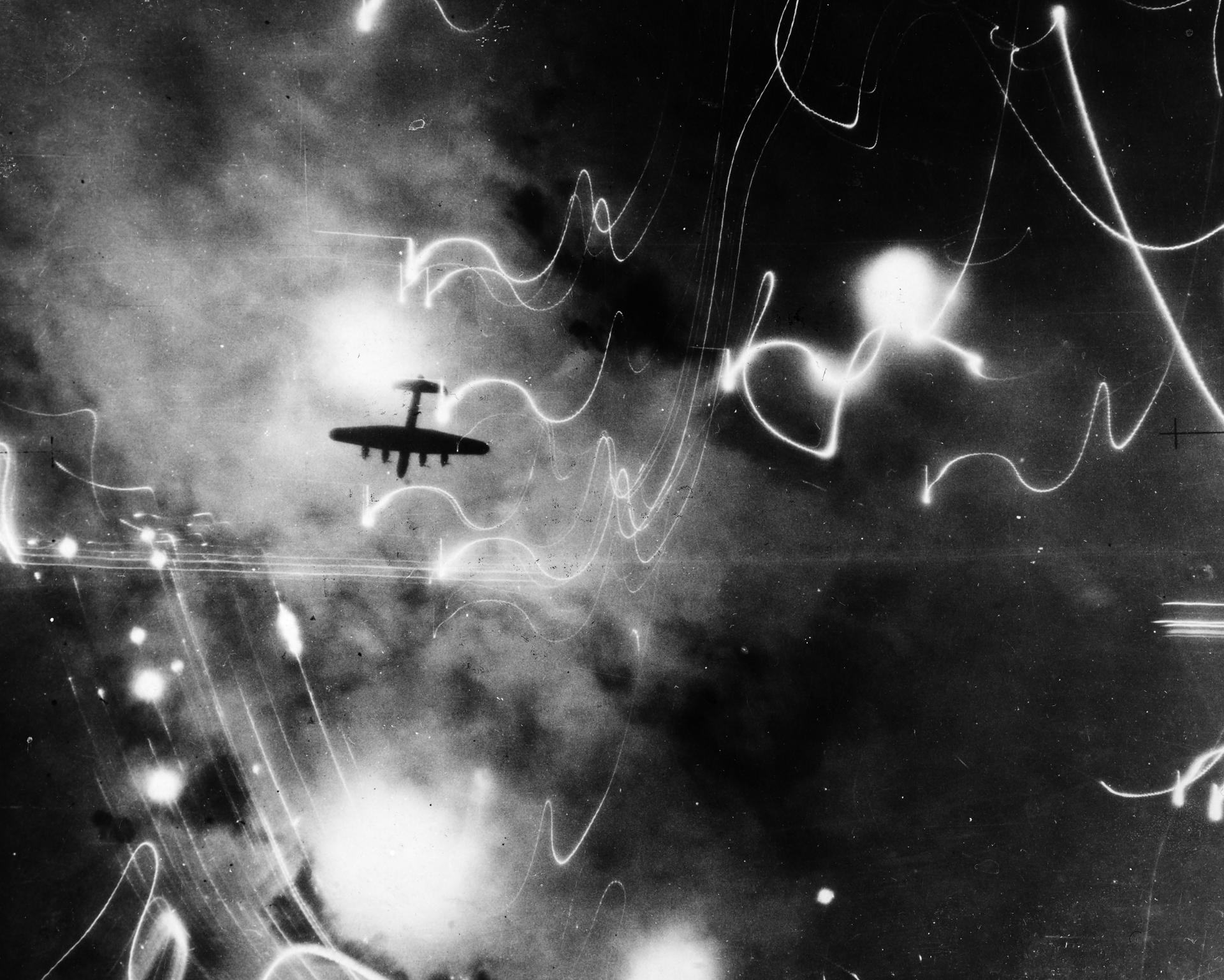 Um Avro 683 Lancaster voa pelo céu noturno durante um ataque da RAF ao porto de Hamburgo em 30 de janeiro de 1943. Este foi o 94º ataque que os britânicos realizam nesta área, o principal centro de produção de submarinos do Reich.