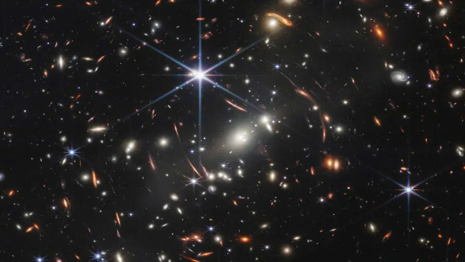 "Campo profundo" com galáxias antigas observadas pelo telescópio James Webb. Galáxias formadas há 13,5 bilhões de anos não têm o brilho previsto pelos melhores modelos atuais da cosmologia após o Big Bang.