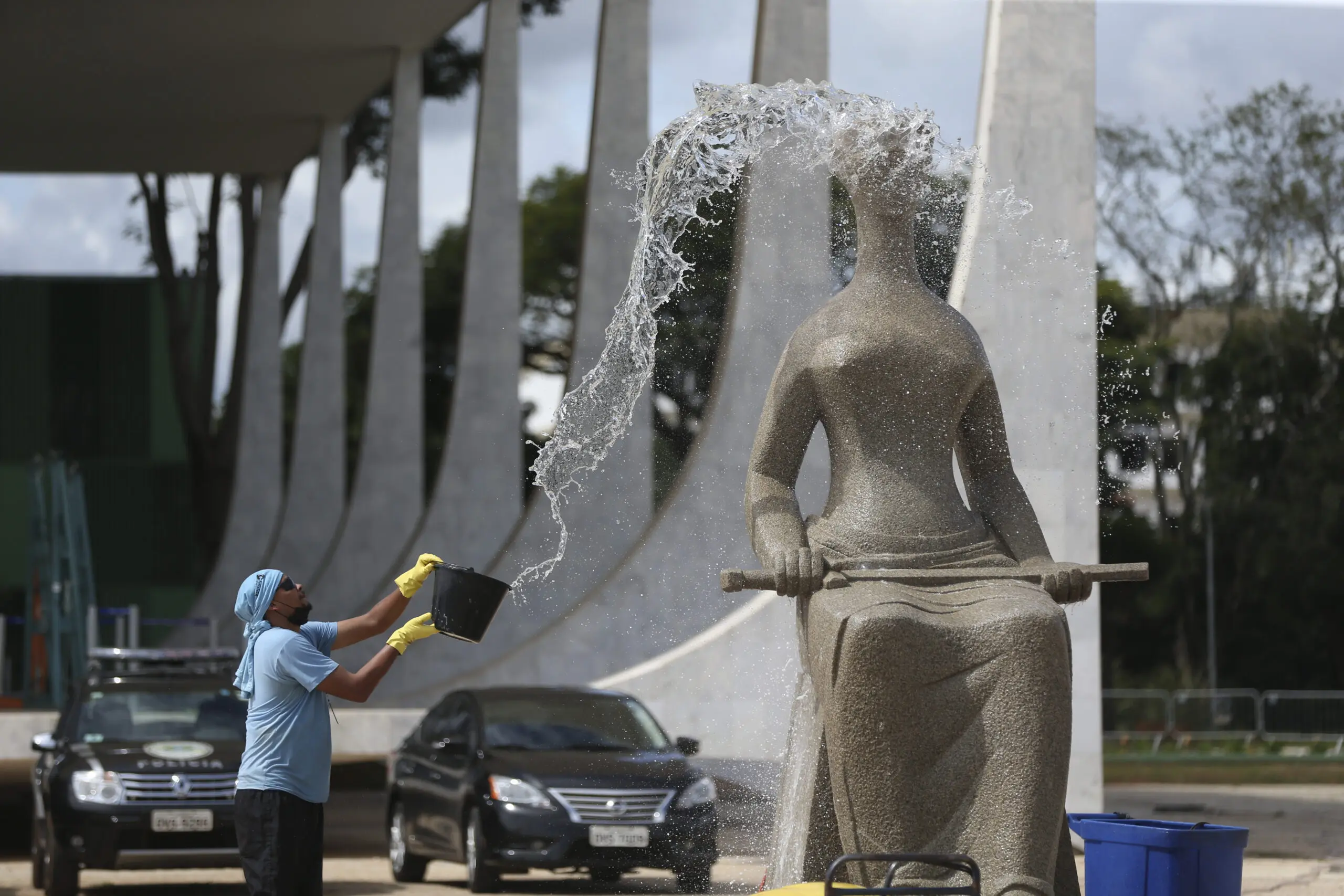 Funcionário lava estátua da Justiça em frente ao STF em janeiro de 2023