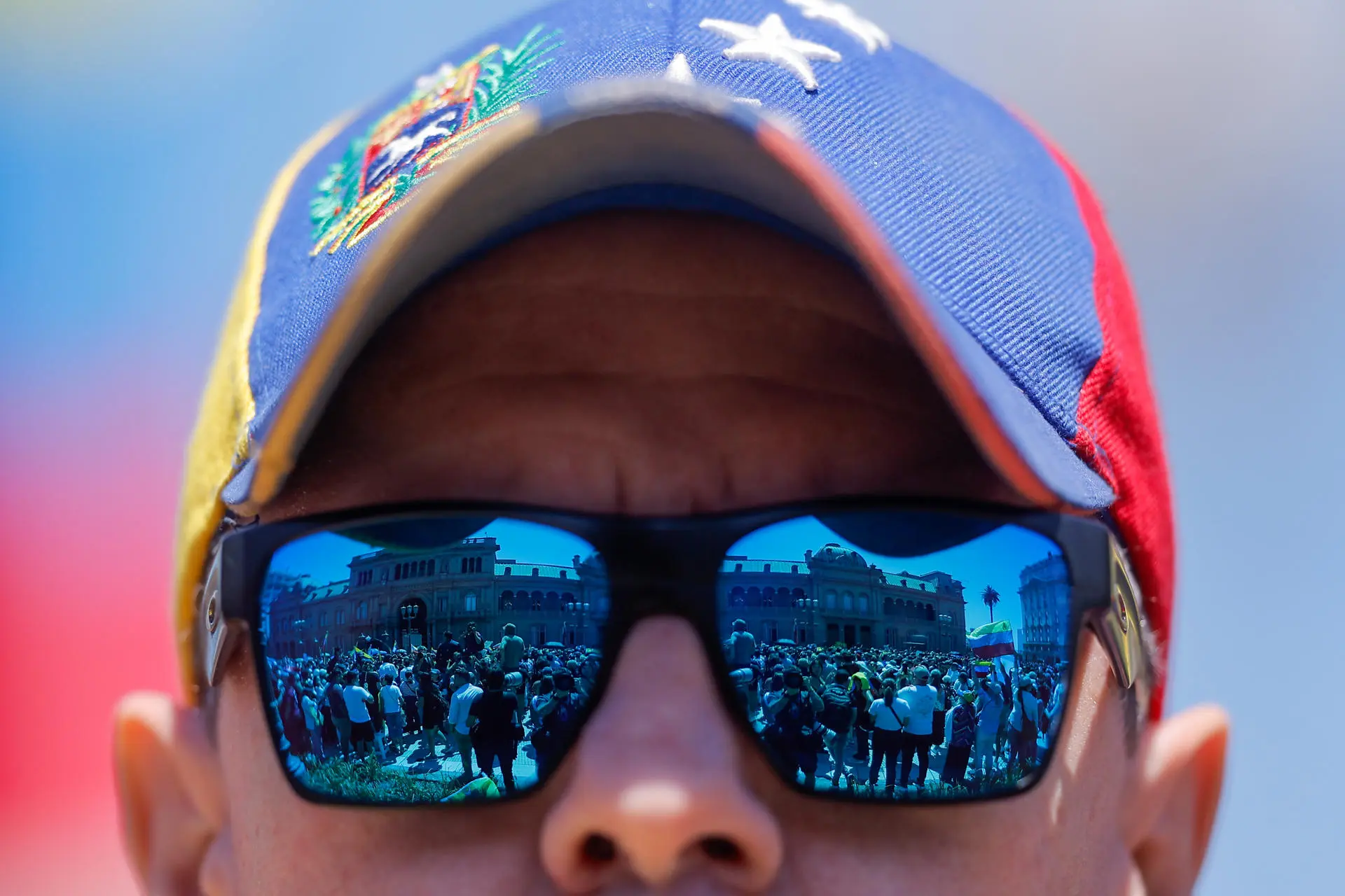 Homem com boné da Venezuela participa de manifestação pela democracia enquanto González Urrutia encontra Javier Milei na Casa Rosada, em Buenos Aires
