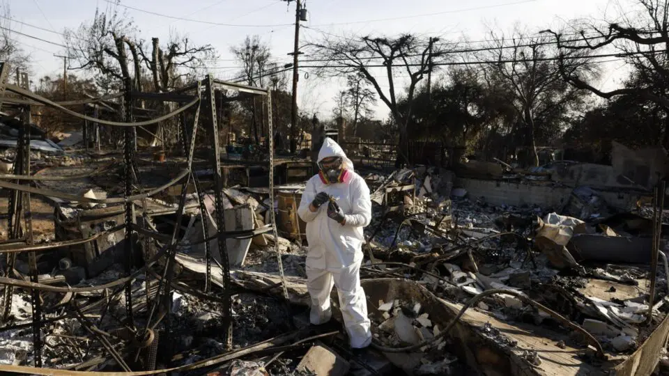 Uma pessoa usando equipamento de proteção vasculha os escombros de sua casa, que foi queimada no incêndio de Eaton, em Altadena, Califórnia, EUA, em 21 de janeiro de 2025.