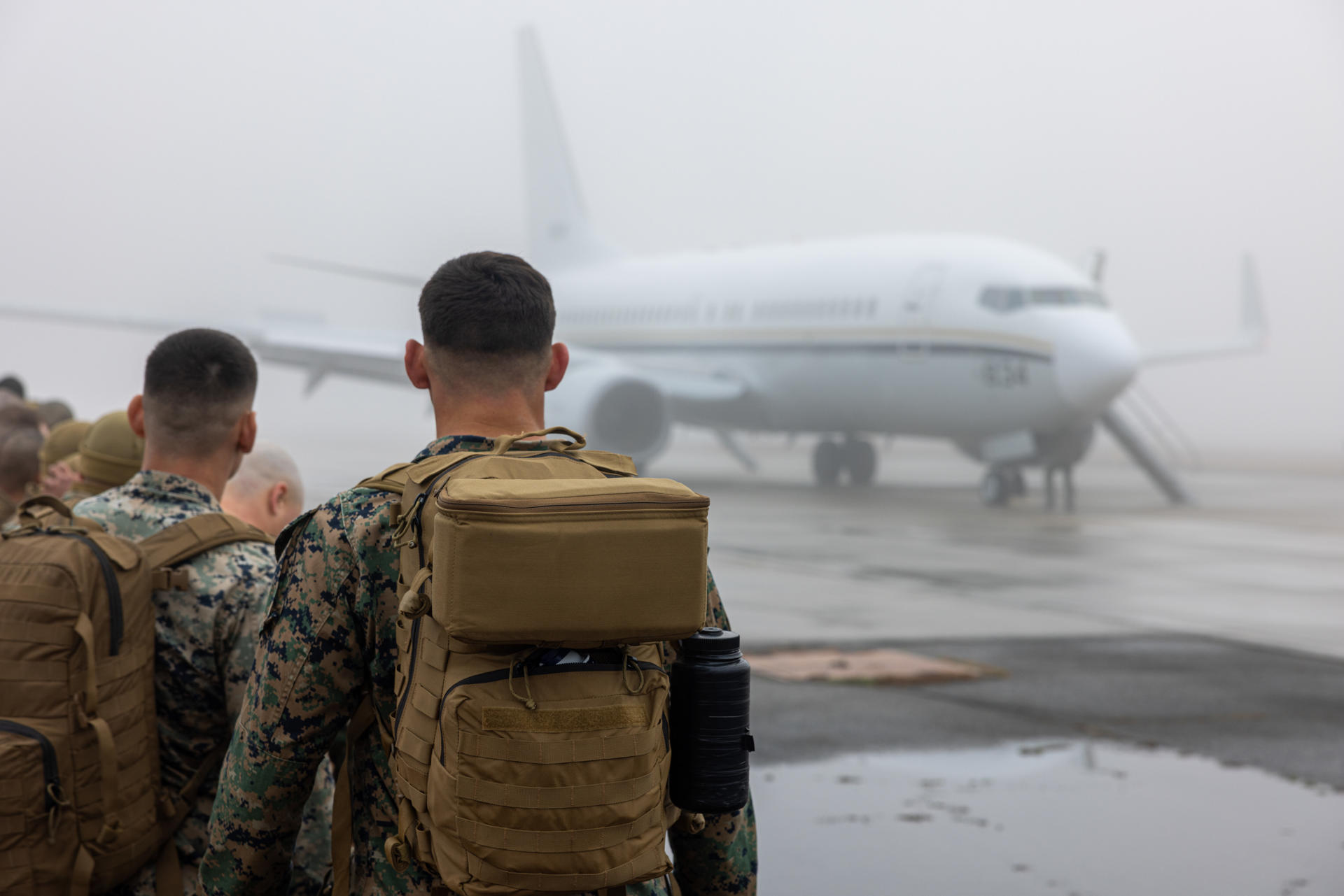 Militares americanos entrando no avião da Força Aérea com destino a Guantánamo
