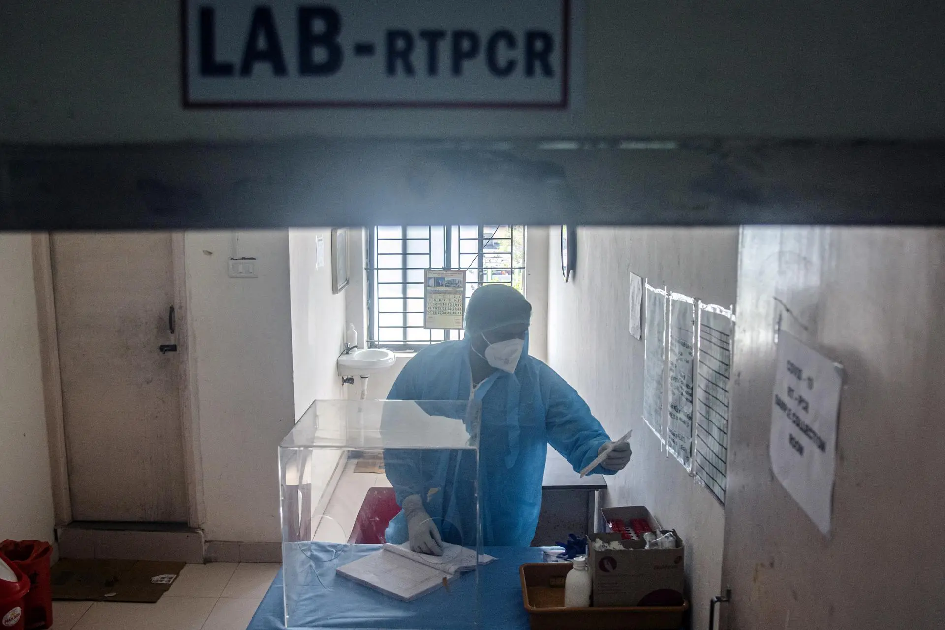 Profissional de saúde indiano usando um equipamento de proteção individual (EPI) trabalha dentro de um laboratório de coleta de amostras de RT-PCR enquanto prepara uma enfermaria de isolamento para tratar pacientes com COVID-19, no Hospital Geral do Governo Rajiv Gandhi, em Chennai, Índia, 27 de dezembro de 2022.