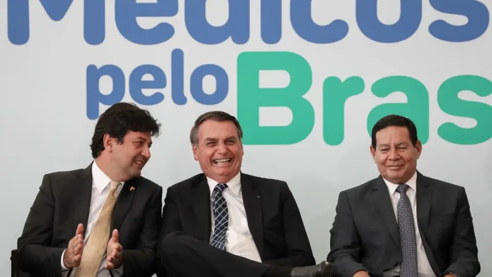 O ex-presidente Jair Bolsonaro com o e-ministro de saúde Luiz Henrique Mandetta e o ex-vice-presidente Hamilton Mourão durante cerimônia de lançamento do Programa Médicos pelo Brasil, em agosto de 2019.