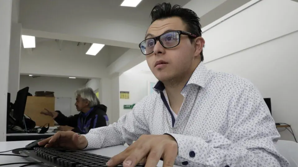 Álvaro Macías, pessoa com síndrome de Down, trabalha no Centro Distrital de Atenção à Inclusão Social (CADIS), em 10 de maio de 2023, em Bogotá (Colômbia).