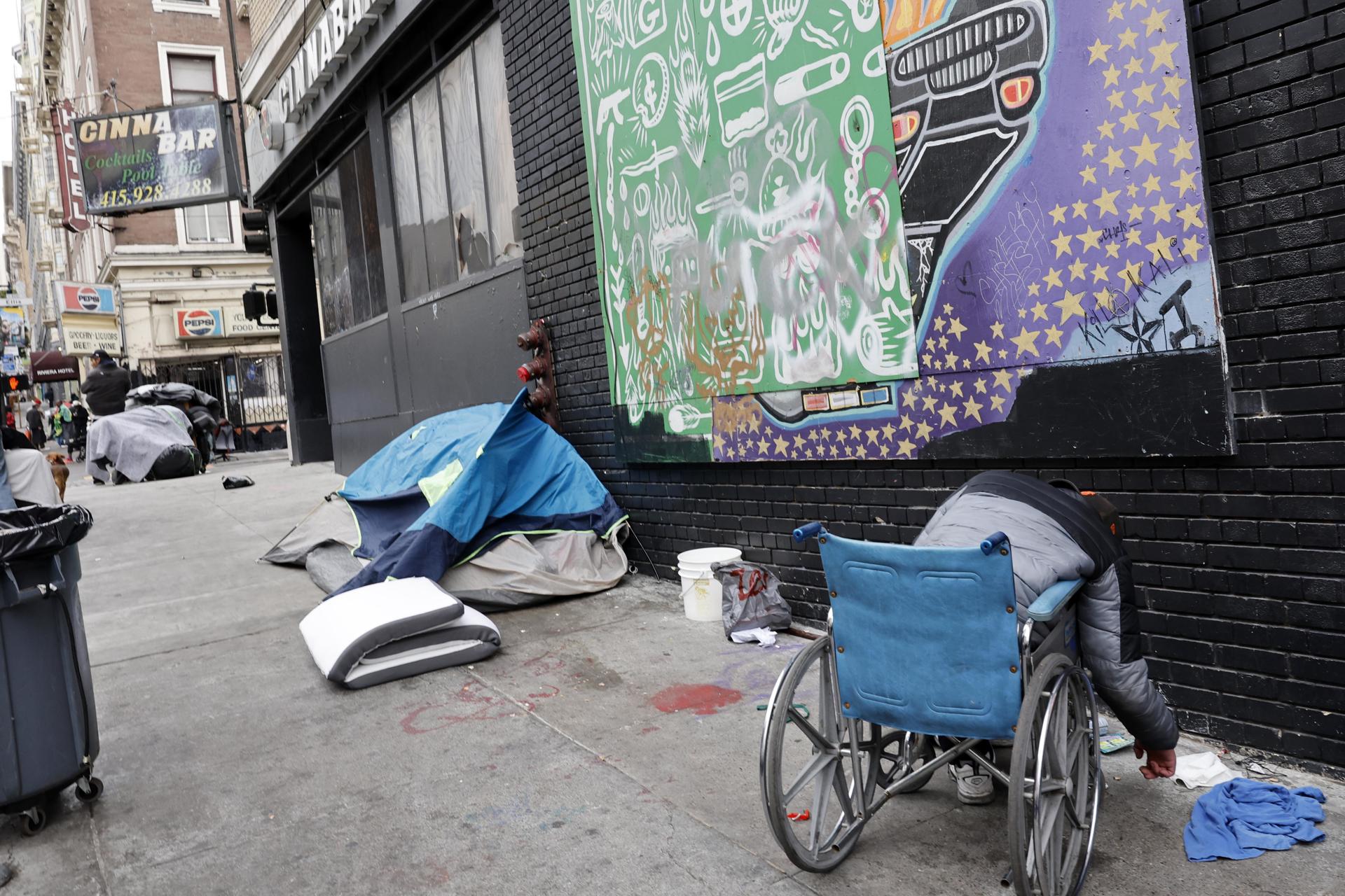 Homem em uma cadeira de rodas reúne seus pertences antes que a equipe da San Francisco Public Works, o Corpo de Bombeiros e os paramédicos limpem um acampamento de moradores de rua em San Francisco, Califórnia, EUA, em 12 de agosto de 2024.