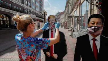 Vendedor de loja de presentes coloca cartazes com a imagem do presidente americano Donald Trump e do presidente chinês Xi Jinping na rua após a reabertura da loja em Moscou, Rússia, em 8 de junho de 2020.
