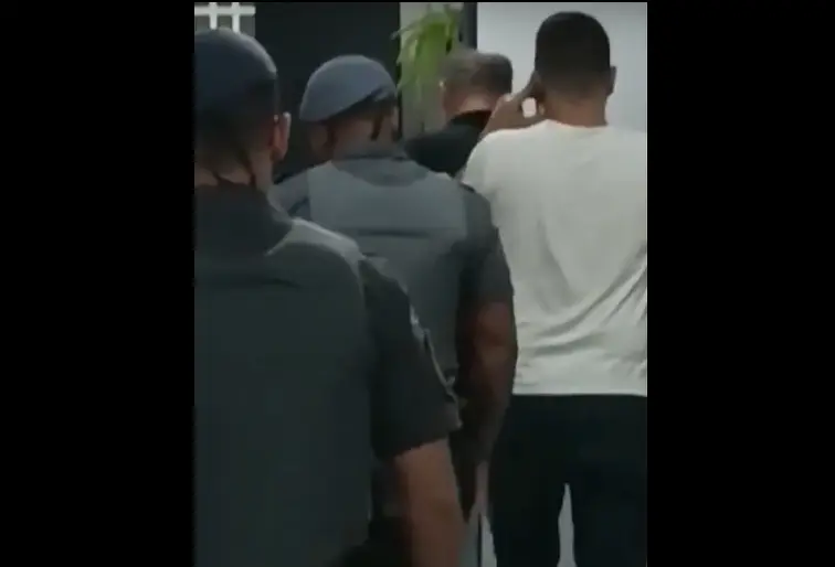 Eduardo Tagliaferro (de preto) sendo conduzido para uma delegacia da Polícia Civil em São Paulo