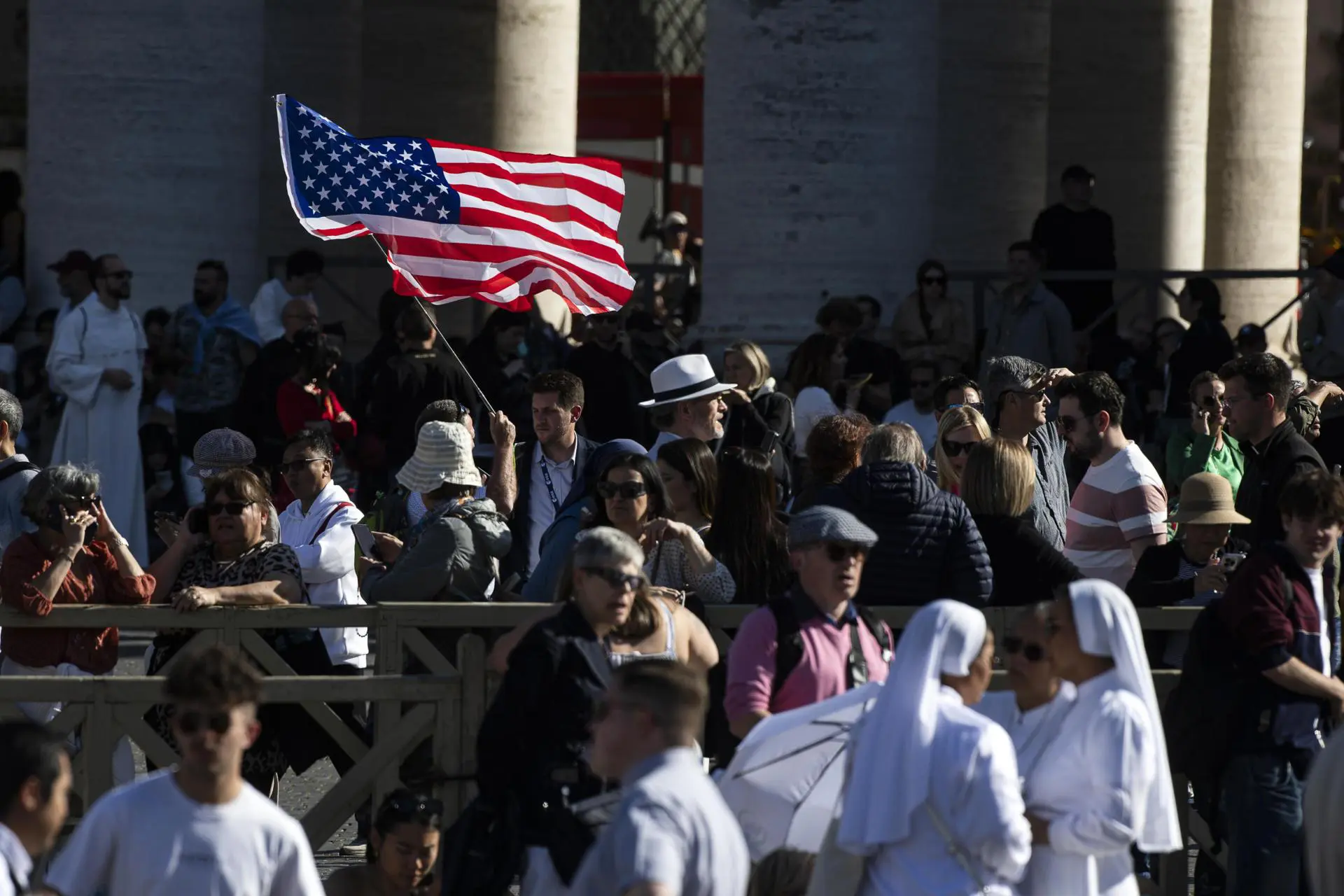 Fiel agita uma bandeira dos EUA na Praça de São Pedro, Cidade do Vaticano, em 8 de maio de 2025