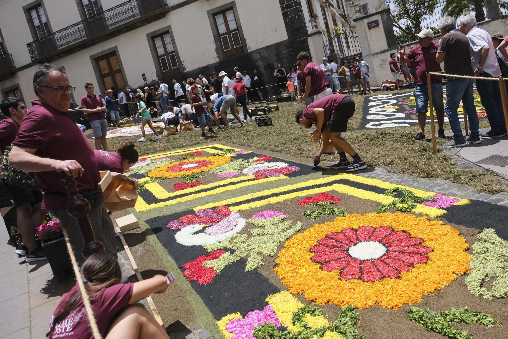 Pessoas decorando o tapete para comemorar a Eucaristia.
