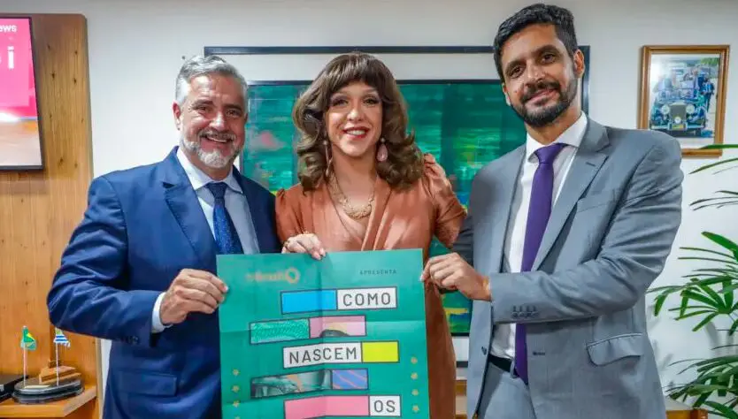 A personagem Rita von Hunty (interpretada pelo ator Guilherme Terreri), com o ex-ministro da Paulo Pimenta e o presidente da EBC, Jean Lima, no anúncio da série "Como Nascem os Heróis".