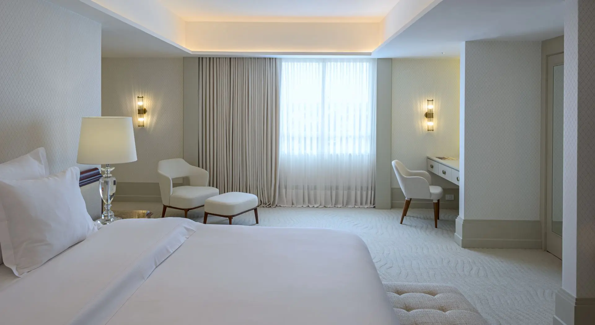 Acorde em grande estilo. A Suíte Presidencial do Bourbon Hotel & Suítes Curitiba te convida a desfrutar de uma estadia inesquecível. Esta foto revela a beleza e o conforto da cama premium, além dos detalhes da sauna privativa e terraço com vista panorâmica de 180 graus. Descubra o verdadeiro luxo em Curitiba