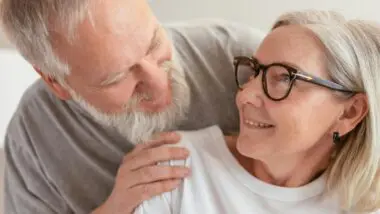 Um casal de idosos, um olhando para o outro.
