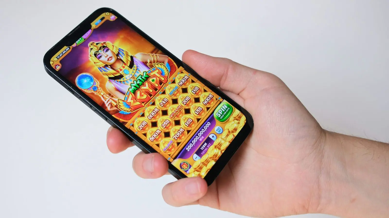 Pessoa segurando um celular na mão. A tela está aberta em um jogo de apostas online.