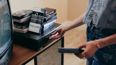 Pessoa escolhendo qual obra vai assistir entre os melhores filmes dos anos 90