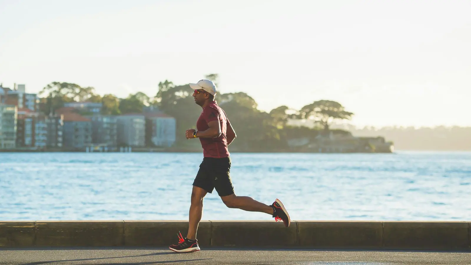 Homem praticando exercício físico na beira do mar.