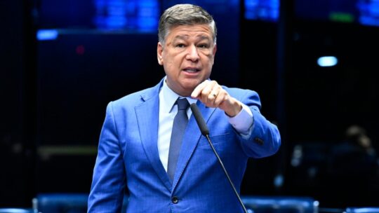 Foto horizontal do senador Carlos Viana falando ao microfone durante sessão da CPMI do INSS.