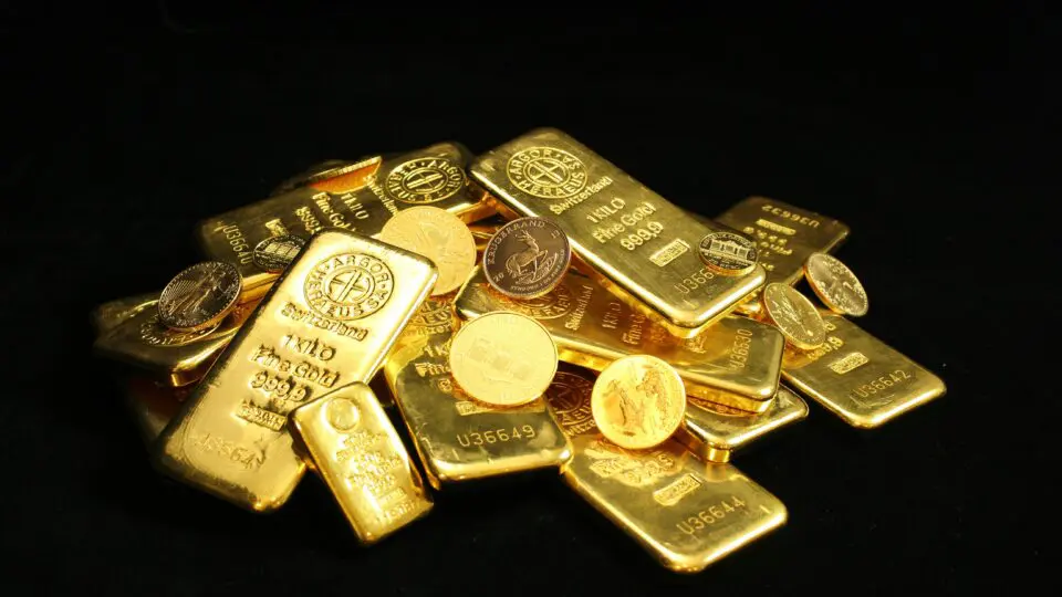 Barras de ouro com moedas de ouro.